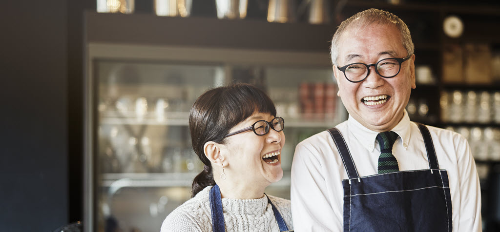 Store owner smiling in store doorwar