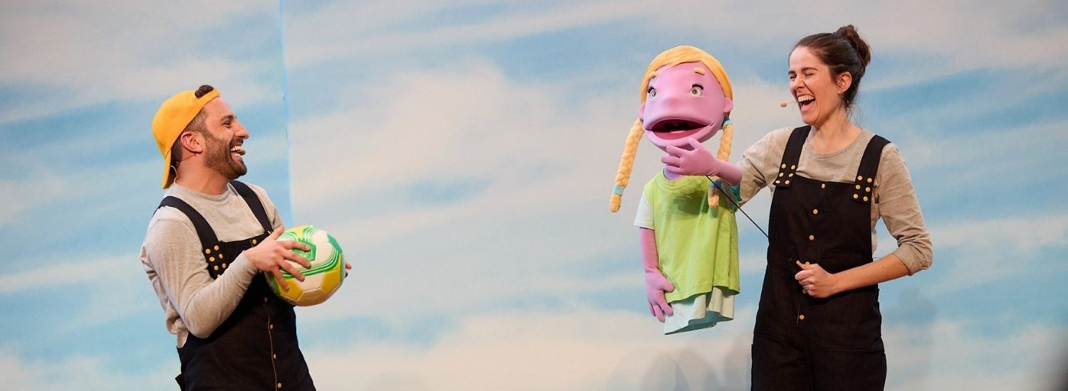 Two puppeteers on stage during a performance
