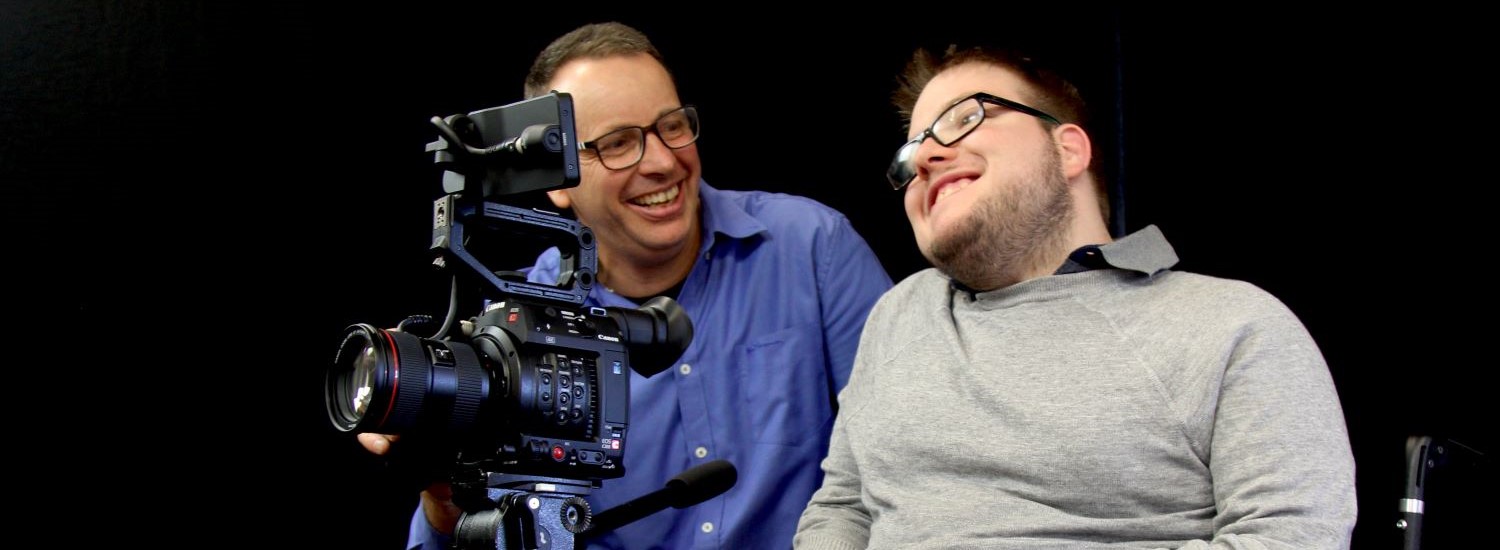 Two men being filmed on stage
