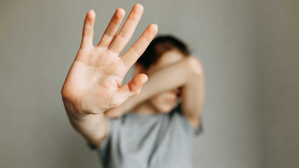 Child holding out hand and blocking defensively