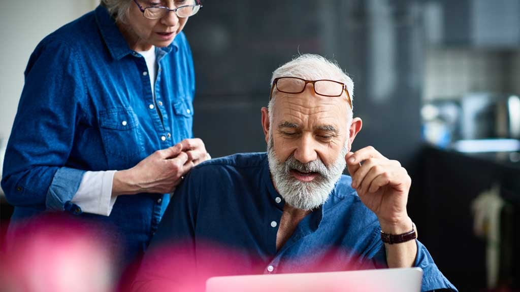 Elderly couple looking at laptop screen