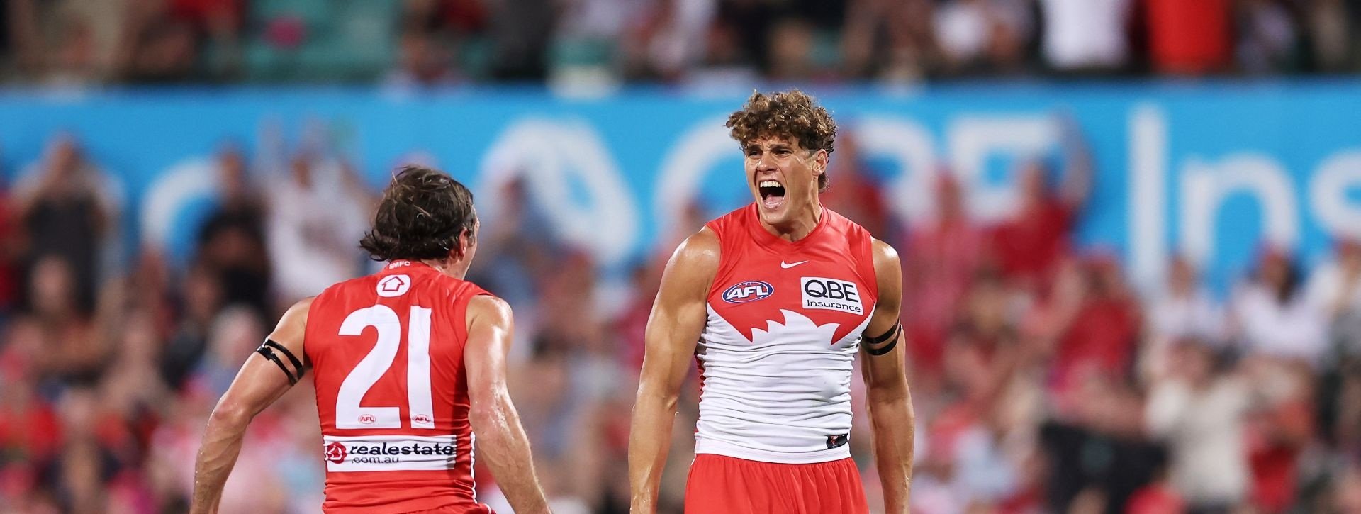 Two Sydney Swans AFL players celebrate during a match