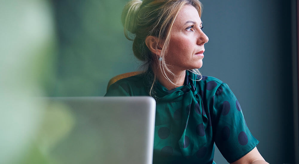 Interrupting Mindsets - Above and Below the Line Mindset - woman gazing away from her laptop