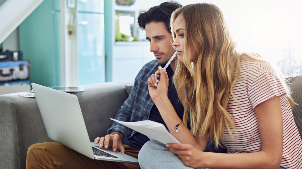 Couple planning their home budget together on the sofa in the living room at home