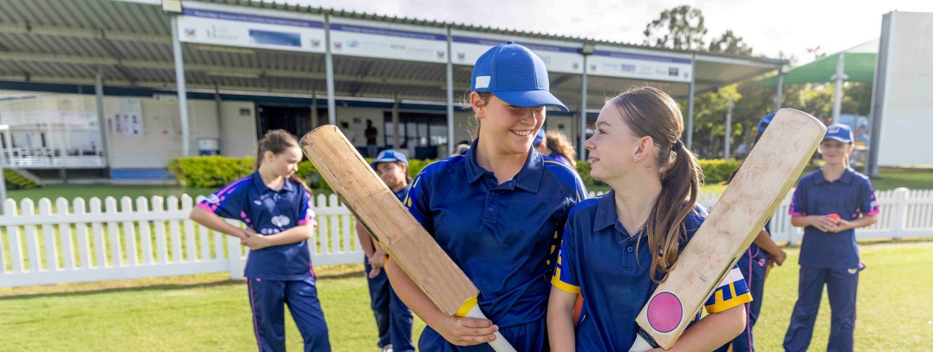 Community cricket players with bats on a cricket field, supported through QBE's partnerships across Aotearoa