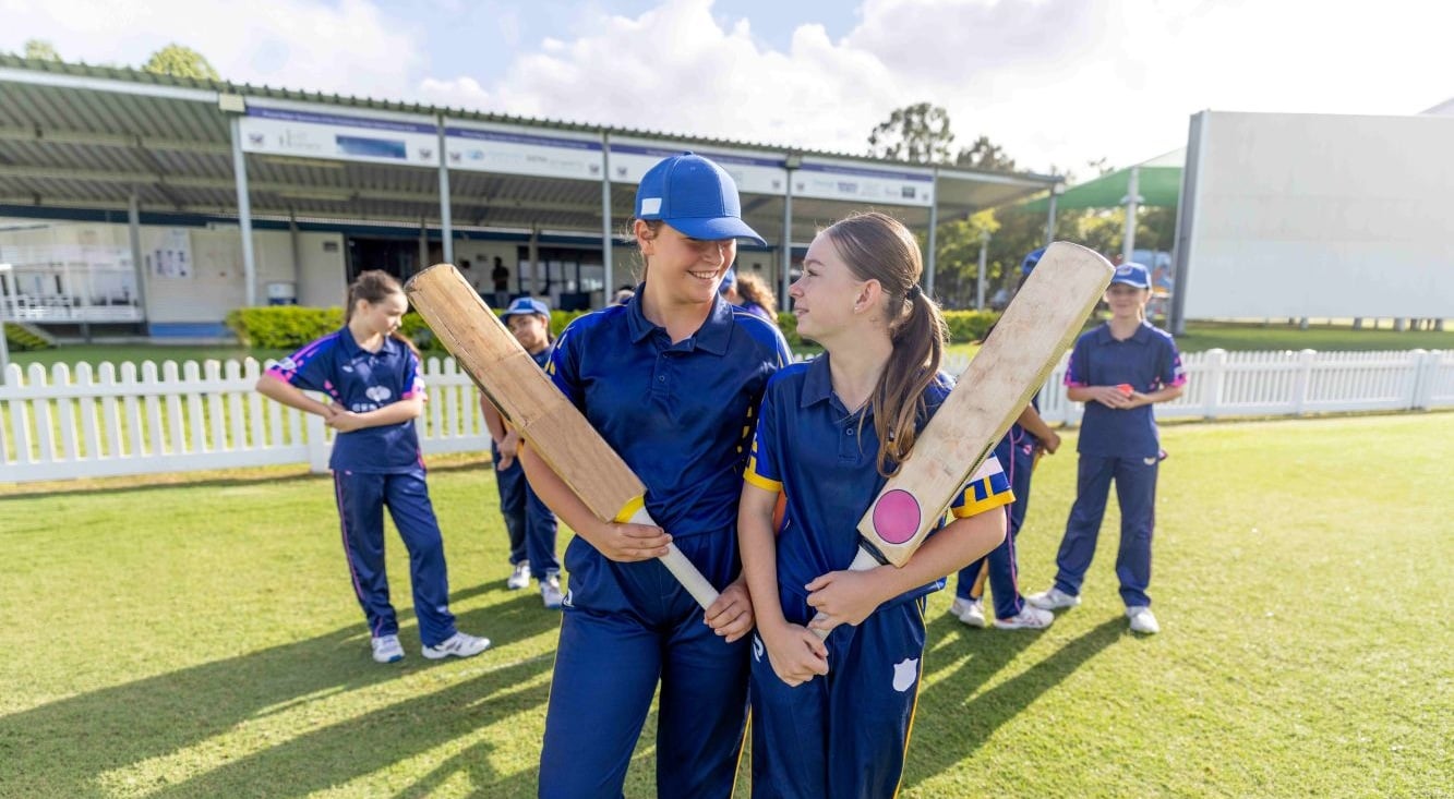 Community cricket players with bats on a cricket field, supported through QBE's partnerships across Aotearoa