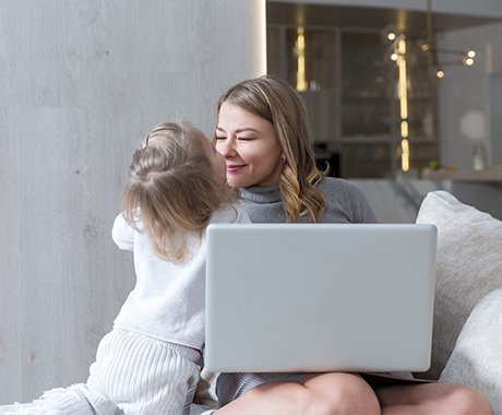 Woman hugging her daughter while working