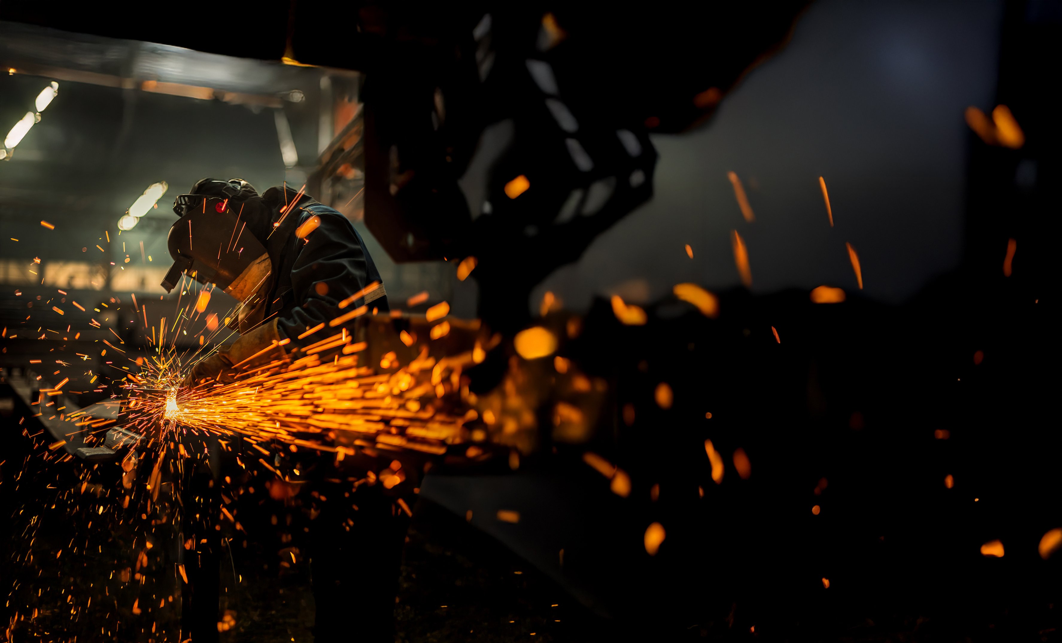Metal worker using a grinder