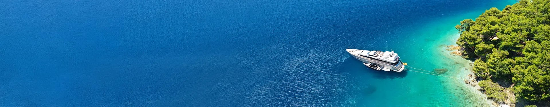 Boat floating in ocean anchored to island