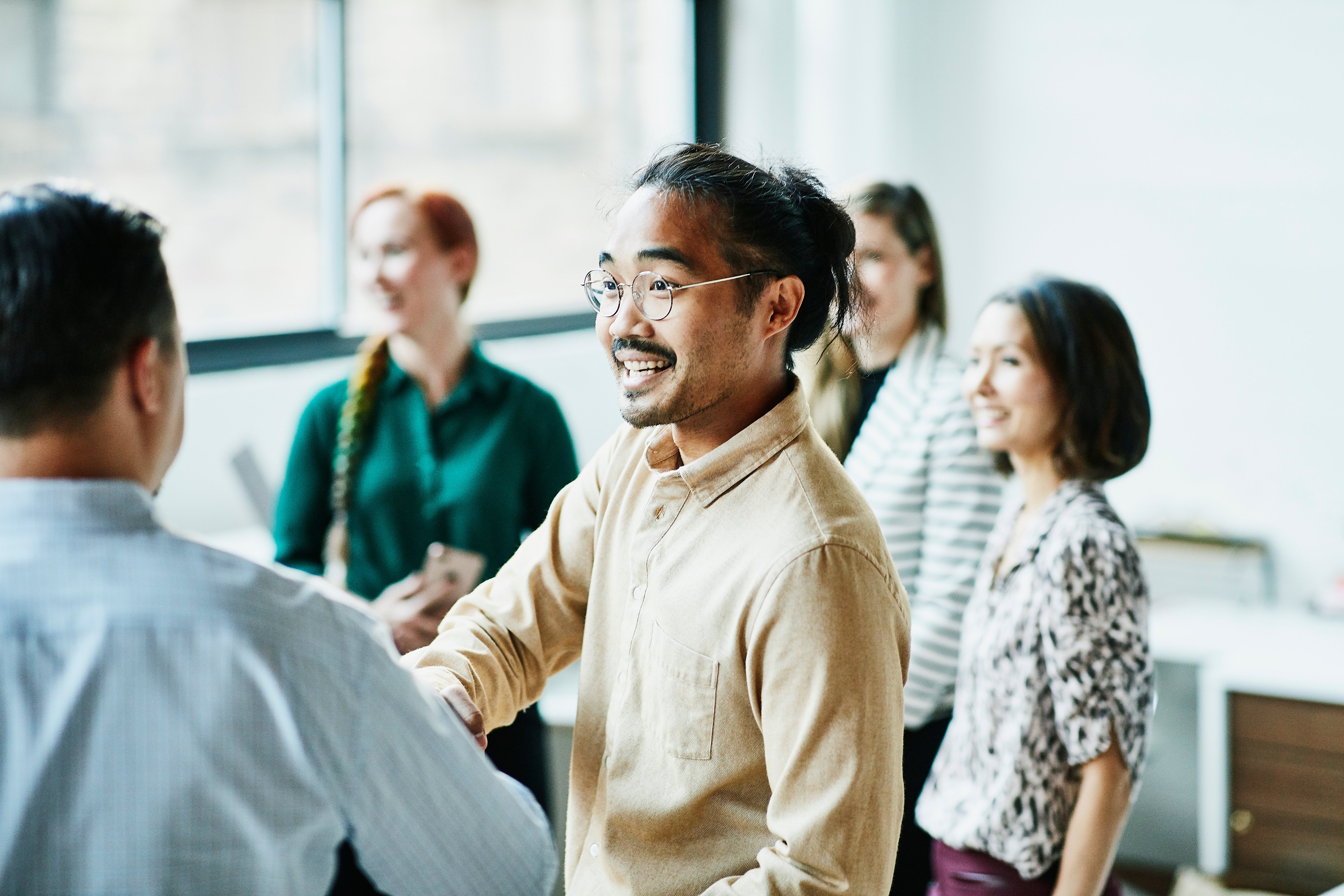 Man shaking hands with his colleagues