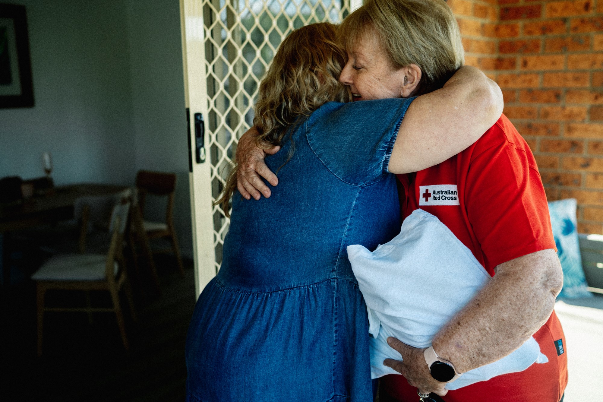 Australian red cross worker hugging a woman