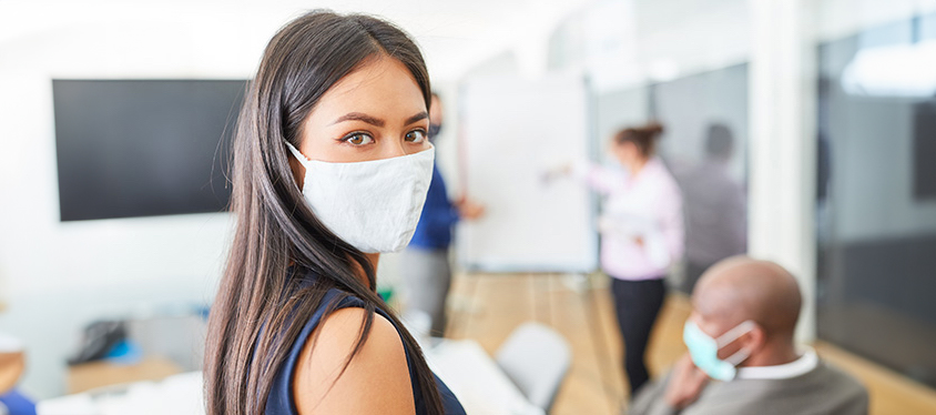 image of a an office space with people working wearing surgical masks