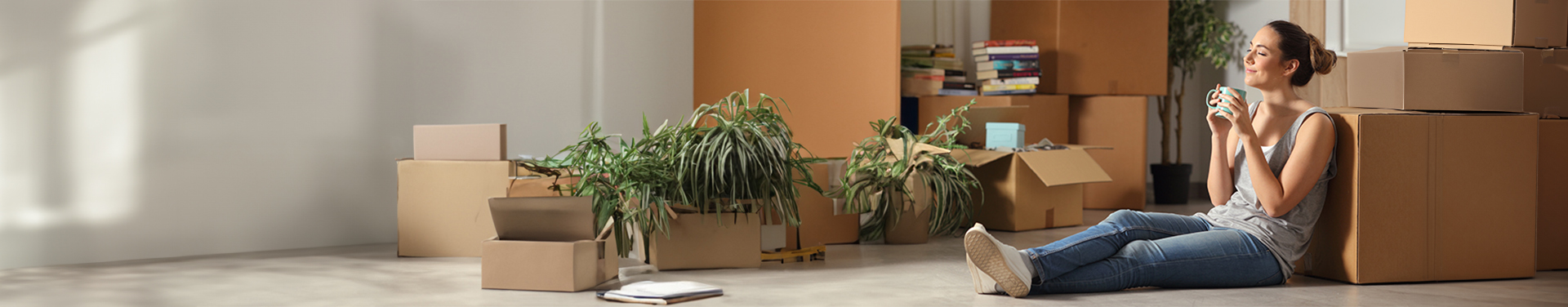 Couple smiling sitting on a couch together surrounded by moving boxes