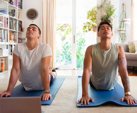 A gay couple do yoga in their home