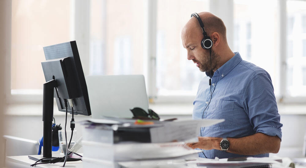 Businessman wearing headphones working at desk in office